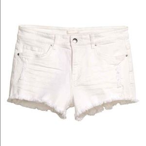 ripped white denim shorts: brand is “H&M”